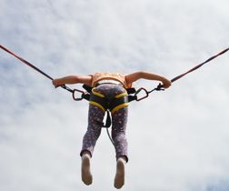 Trampolin springendes Kind mit Seilen